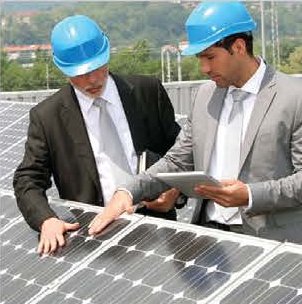 Engineers reviewing plans beside solar panels